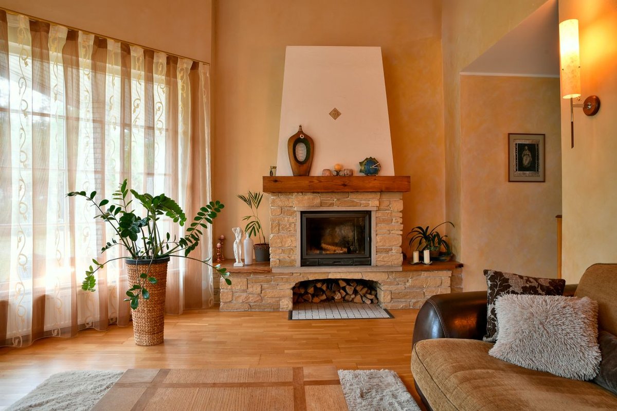 Warm and inviting living room featuring a rustic stone fireplace and charming decor.