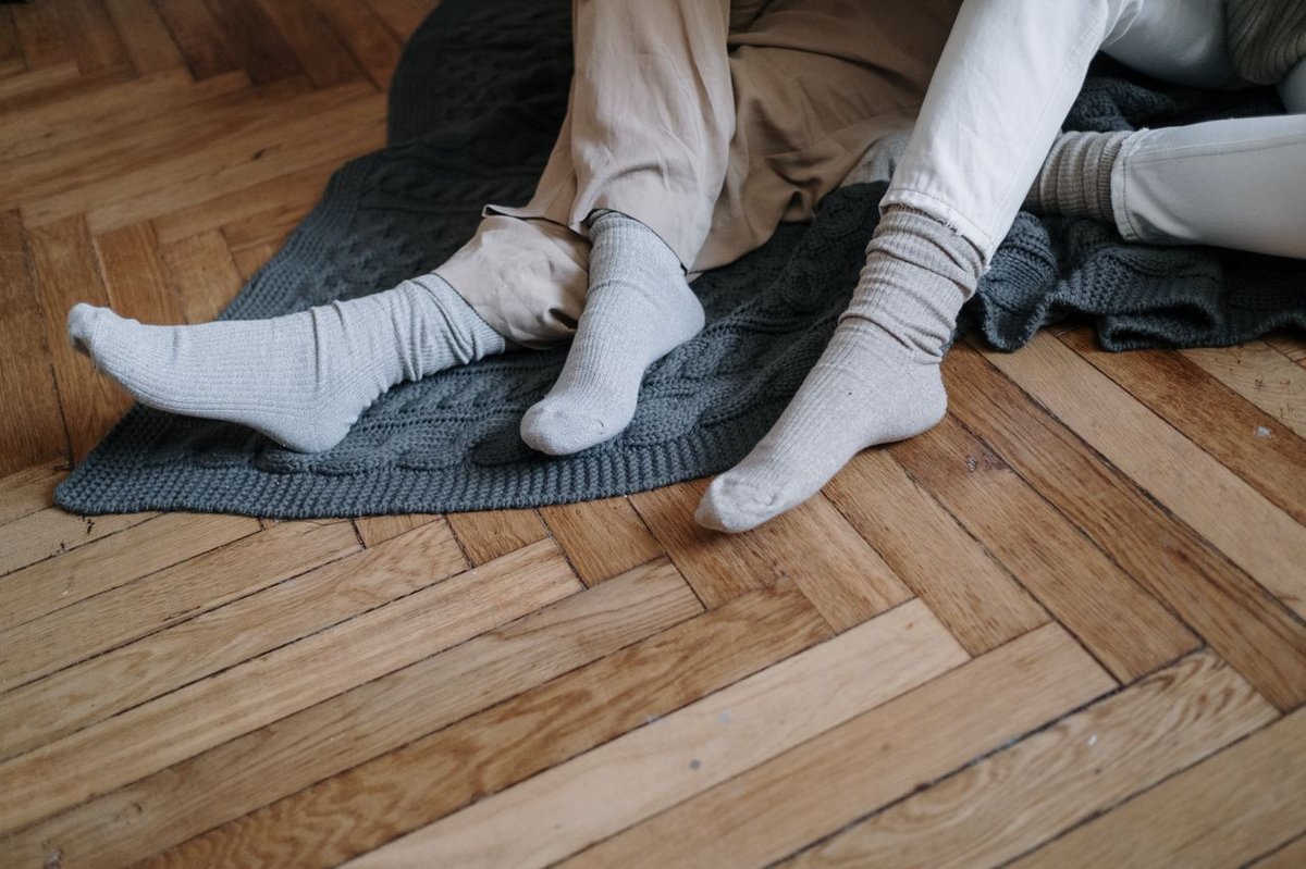 couple sitting on wooden floor with their socks on