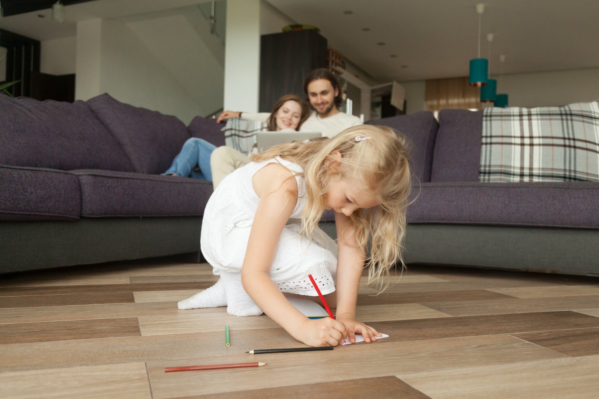 Cute girl daughter drawing with colored pencils playing at home