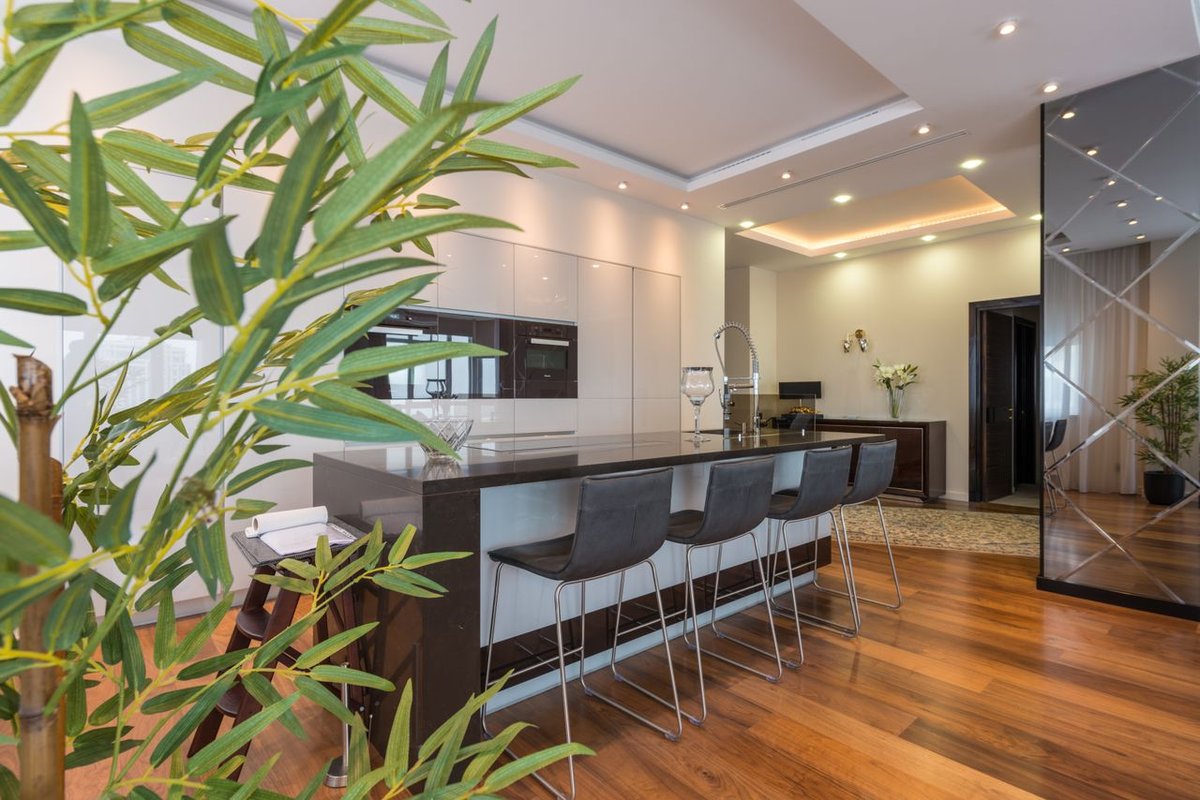 Contemporary kitchen with sleek design, featuring an elegant island and comfortable bar stools.