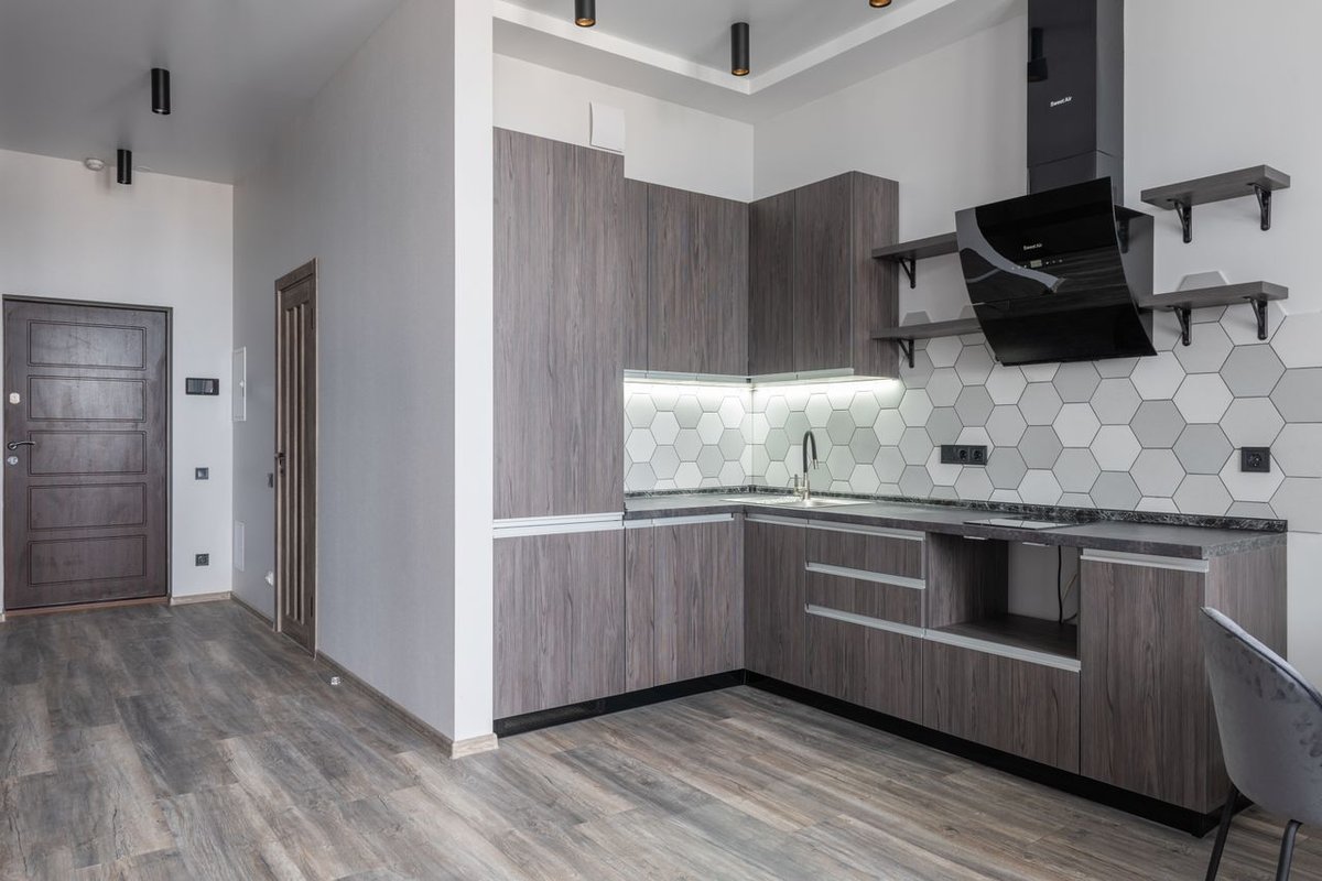 Sleek and contemporary kitchen with wooden cabinetry and hexagonal tiles.