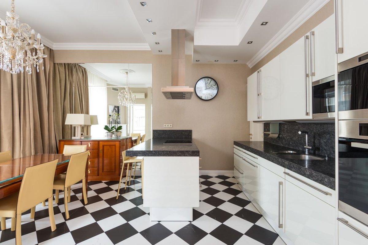 Spacious contemporary kitchen and dining room with stylish interiors and checkered flooring.