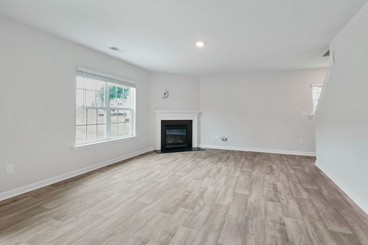Bright and spacious living room featuring a modern fireplace and parquet flooring, ideal for contemporary interiors.