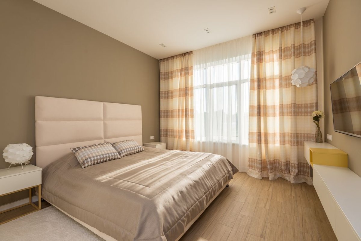 A bright and cozy bedroom featuring modern decor with a warm ambiance.