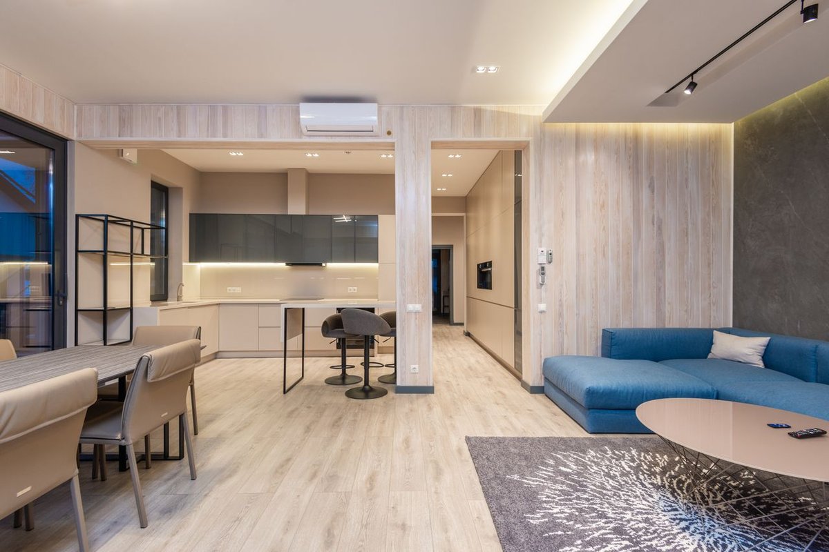 Bright, contemporary living and dining area with sleek furniture and ample lighting.