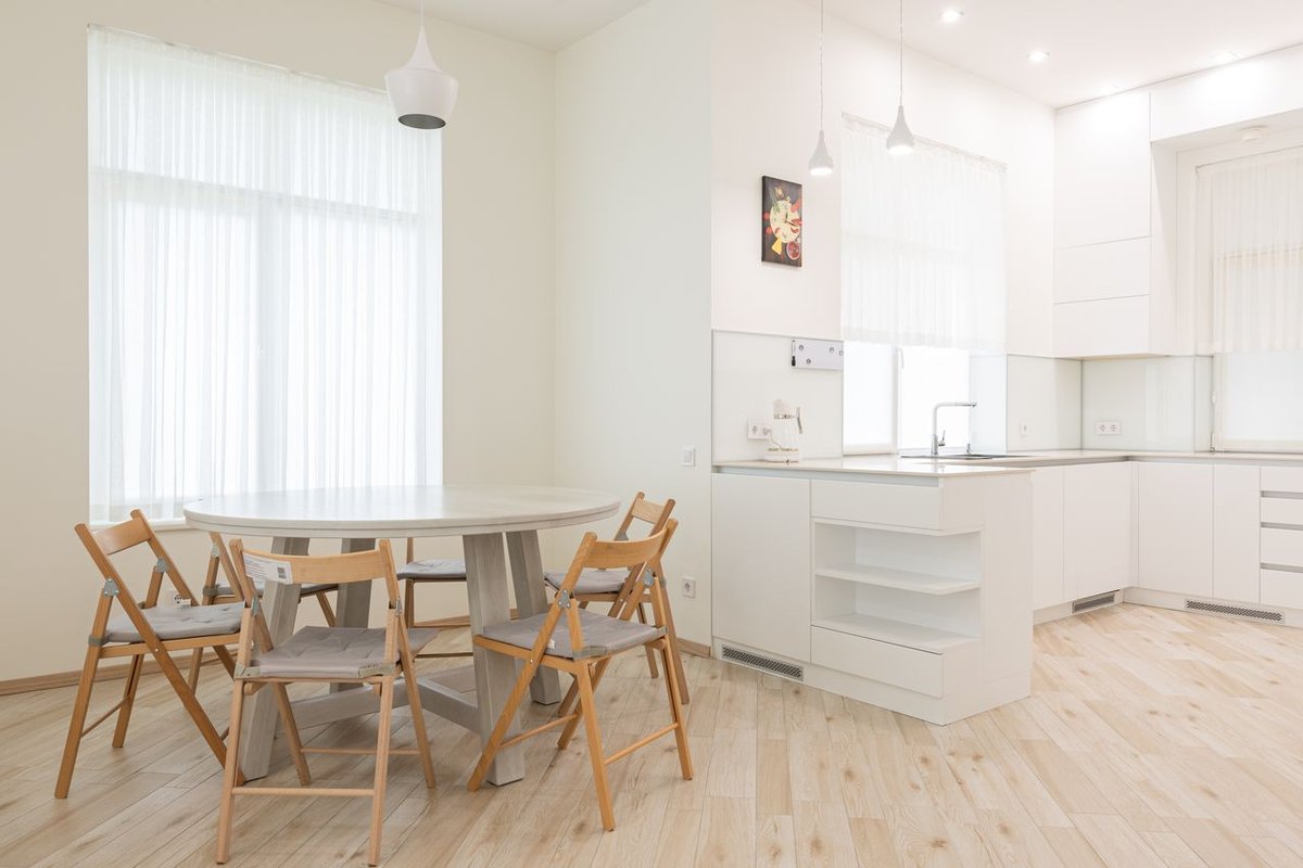 Spacious and airy dining room with modern minimalist decor, featuring wooden furniture and natural light.