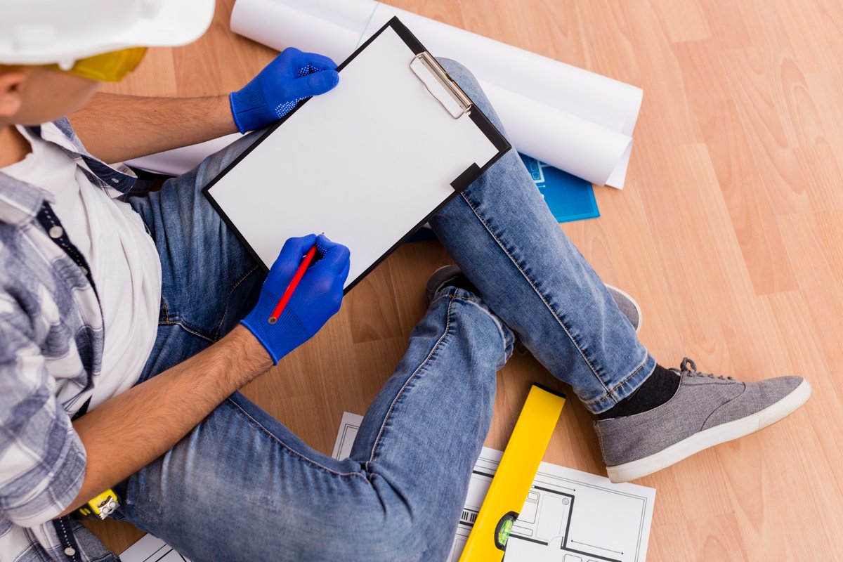 Top view of man holding a clipboard while sitting on the floor