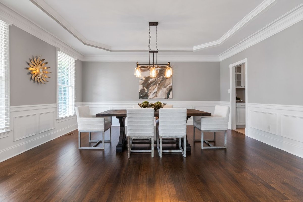 a dining room with wooden table, chairs and floor