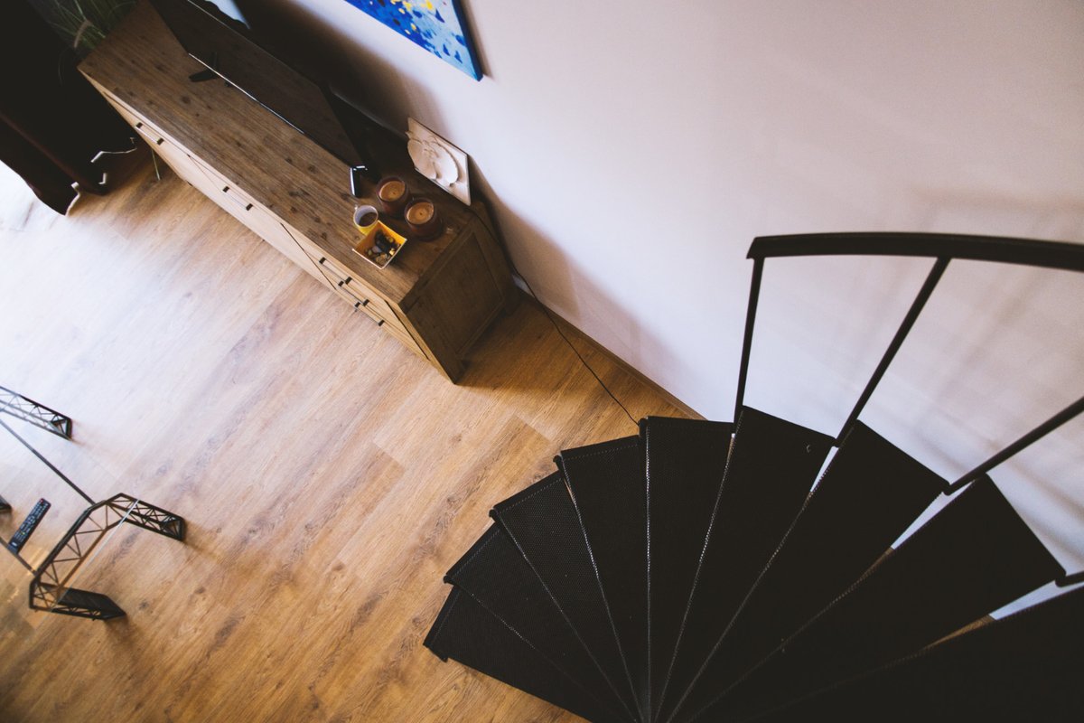 A staircase leading down to a basement with laminate flooring