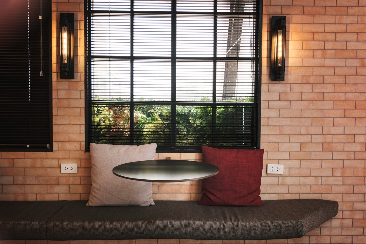 Interior of a cafe with brick walls and black blinds