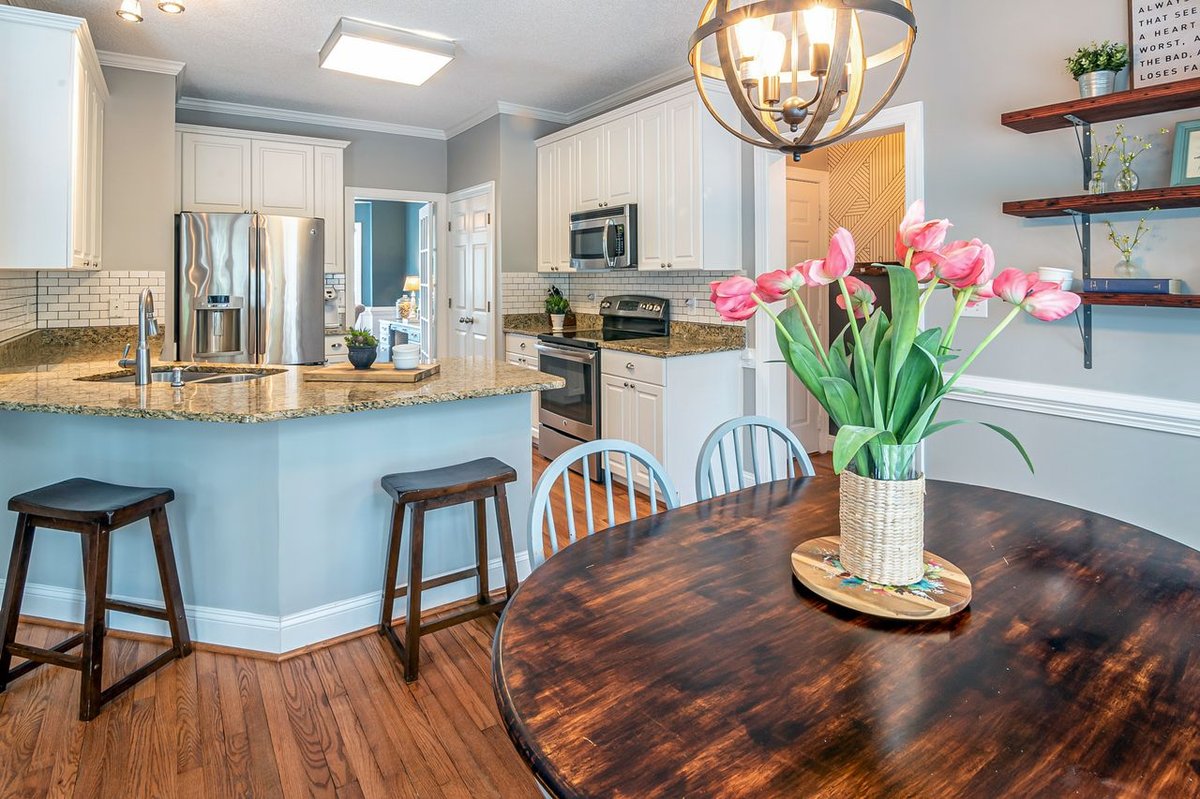 A modern and cozy kitchen with tulips on a dining table, showcasing elegant interior design.