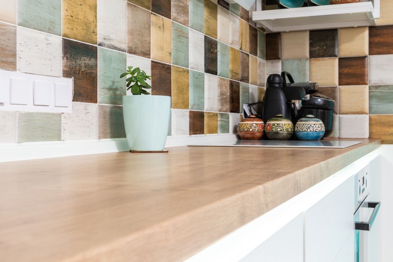 A modern kitchen counter with a vibrant tile backsplash and decorative elements.