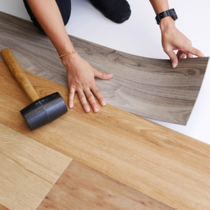 Cropped hands of woman adjusting Vinyl Flooring on floor
