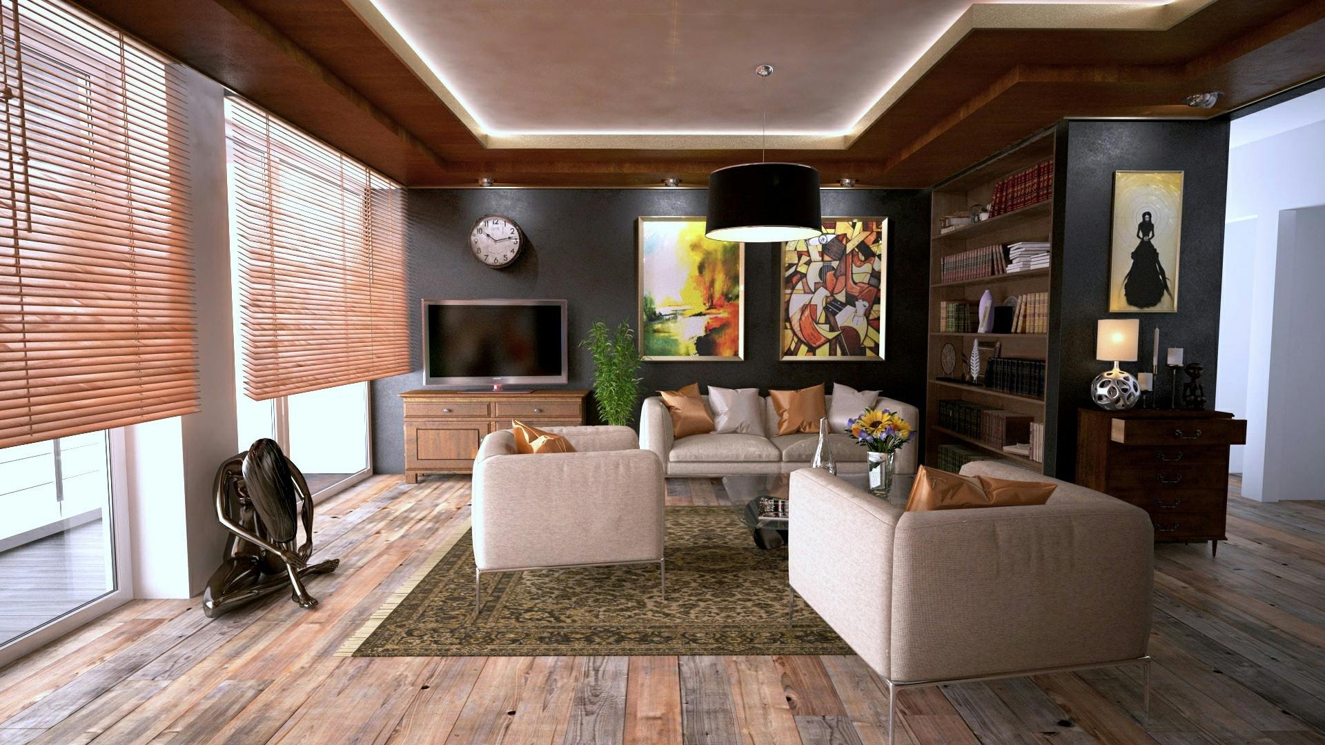 Stylish living room with wooden floors, beige seating around a glass coffee table, and large windows with wooden blinds. The space features vibrant artwork, built-in shelves, a media console with a mounted TV, and warm natural light. A vacuum cleaner sits