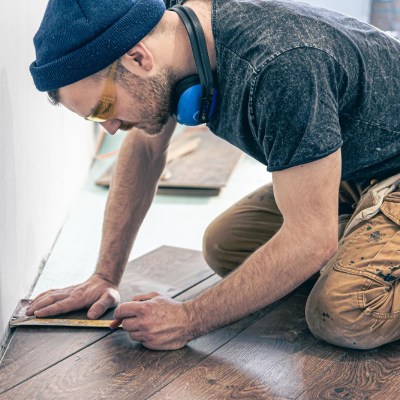 A male worker puts laminate flooring on the floor